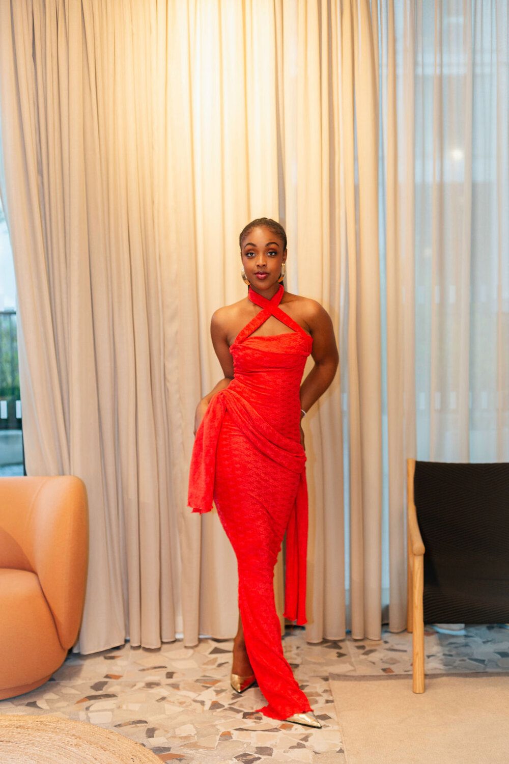 The Esther Royale Gown in red &mdash; by the curtain, sash draped
